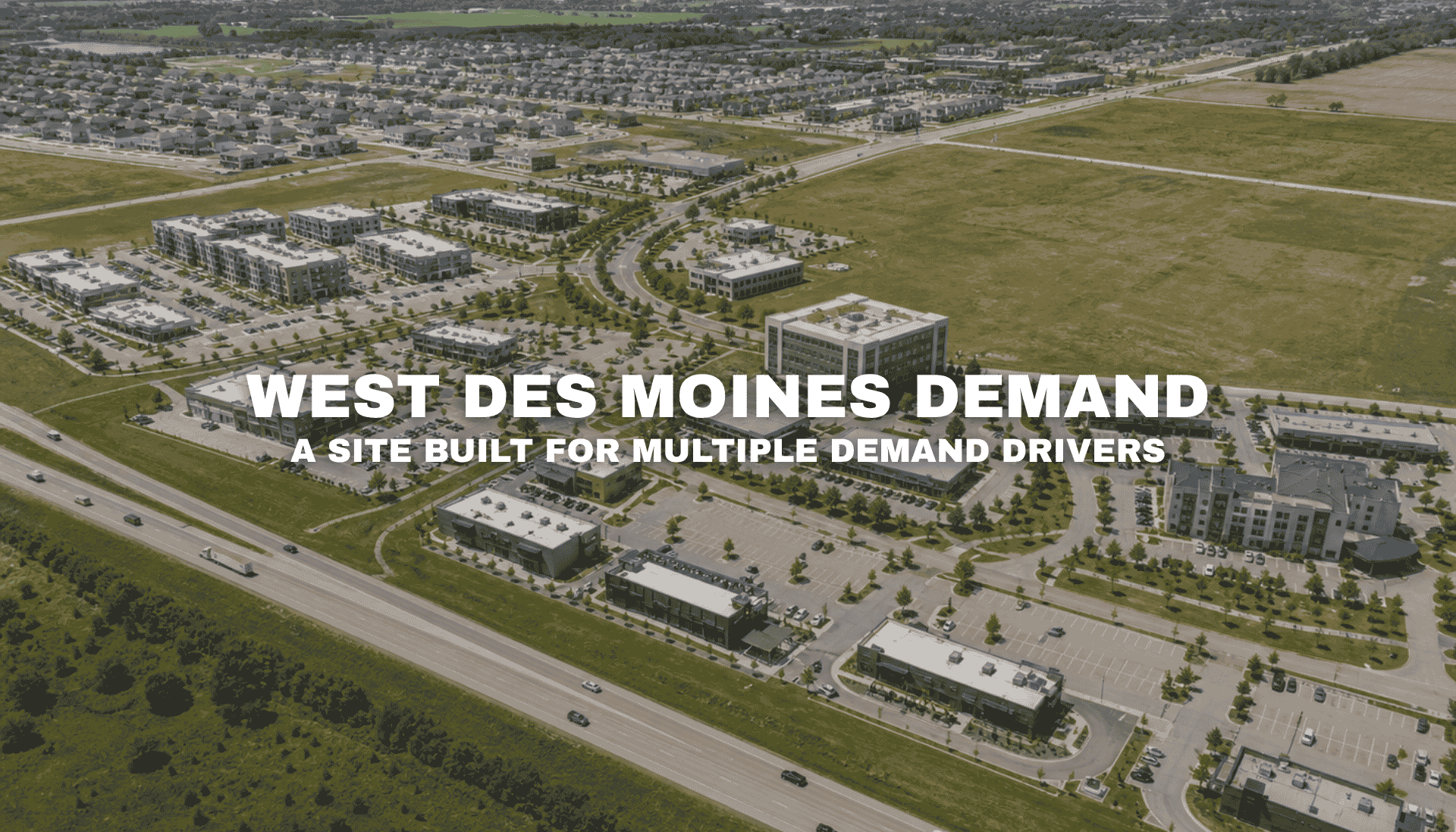 Aerial view of Pavilion Park in West Des Moines with modern mixed-use buildings, commercial pads, office and residential elements, broad roads, open land, and nearby interstate access.