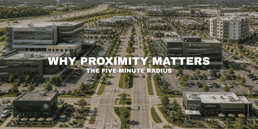 Elevated view of a commercial corridor in West Des Moines with office buildings, retail, dining, medical uses, broad roads, parking, and interstate access near Pavilion Park.
