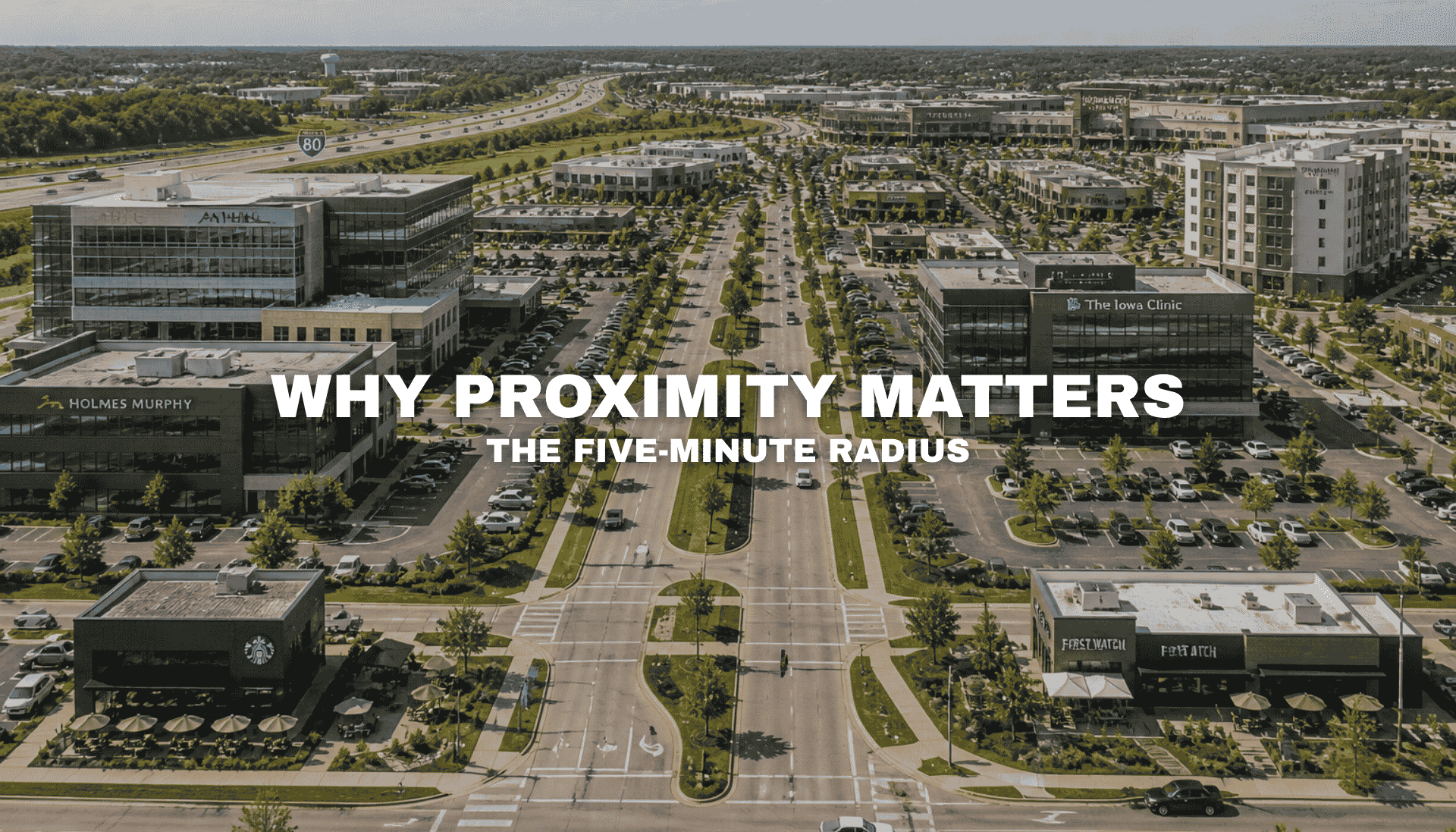 Elevated view of a commercial corridor in West Des Moines with office buildings, retail, dining, medical uses, broad roads, parking, and interstate access near Pavilion Park.